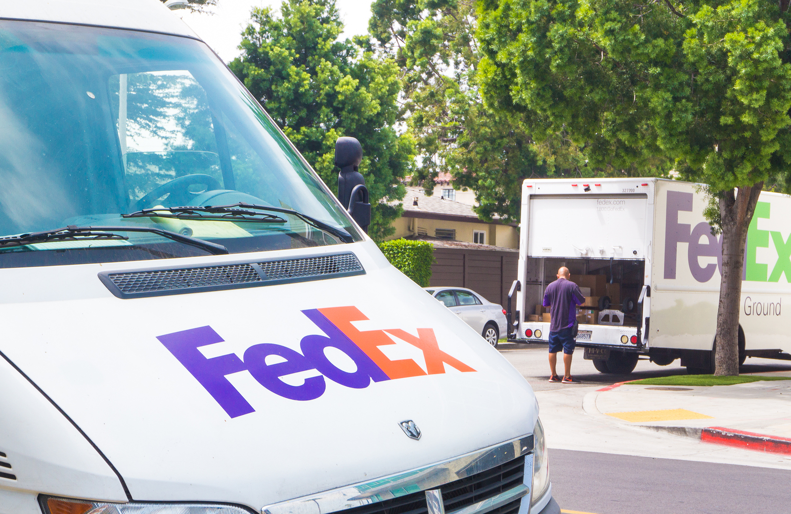 A delivery man dropping off packages on new FedEx delivery days.